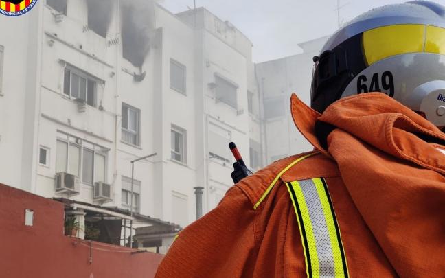 Un bombero apaga un incendio en una vivienda.