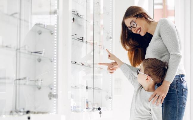 Un ni&ntilde;o elige gafas en una &oacute;ptica.