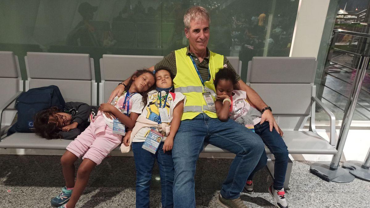 Uno de los monitores del programa Oporrak Bakean, Jose Antonio Sáez de Cámara, aguarda en el aeropuerto de Loiu de madrugada junto a las menores saharauis Jadyatu, Ana y Mati, vecidas por el sueño.