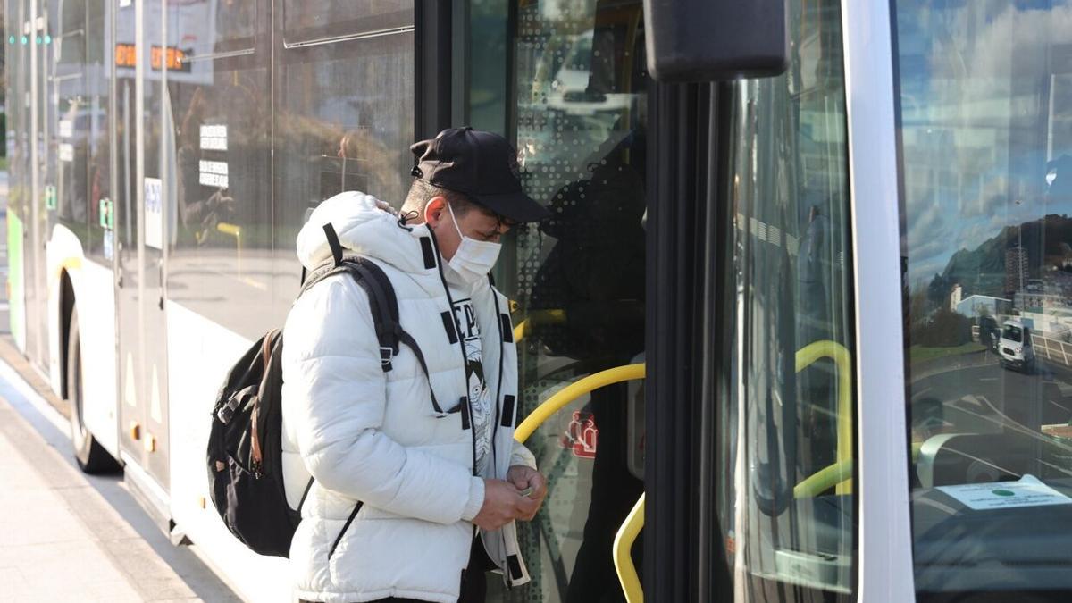 Un joven entra con su mascarilla en un autobús