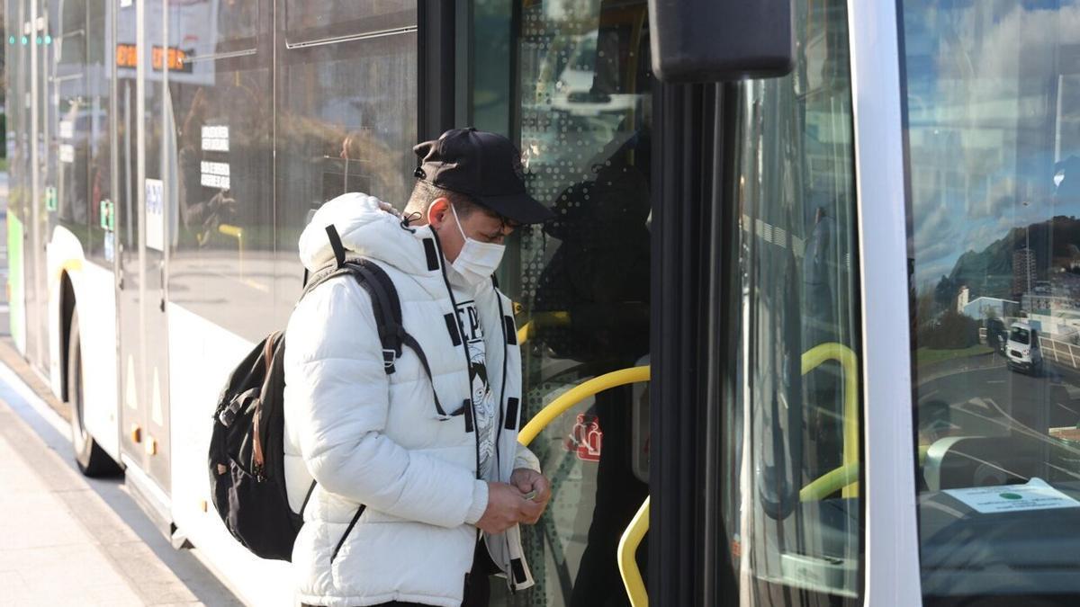 Un joven entra con su mascarilla en un autobús