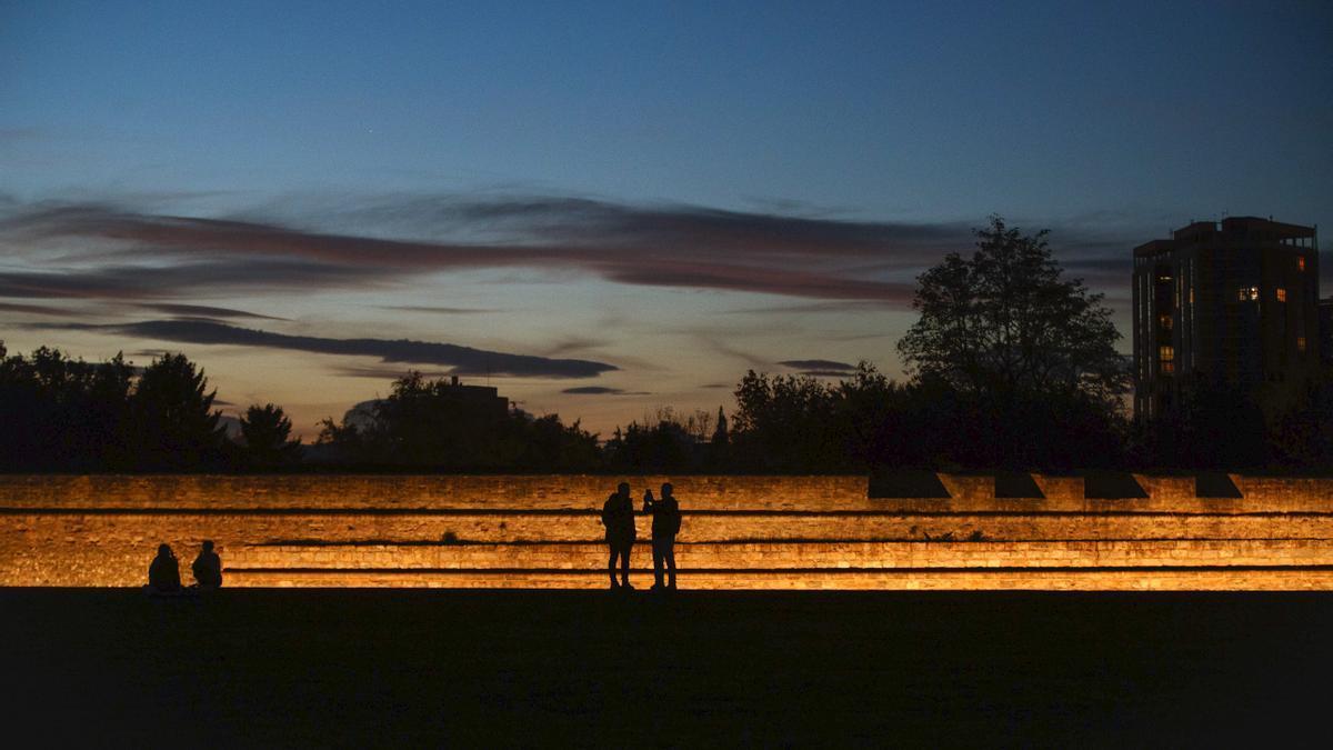 Varios jóvenes acuden a la Vuelta del Castillo de Pamplona para ver el atardecer de este domingo de la capital navarra tras una jornada en la que el cielo estuvo poco nuboso o despejado, con temperaturas agradables para estas fechas.