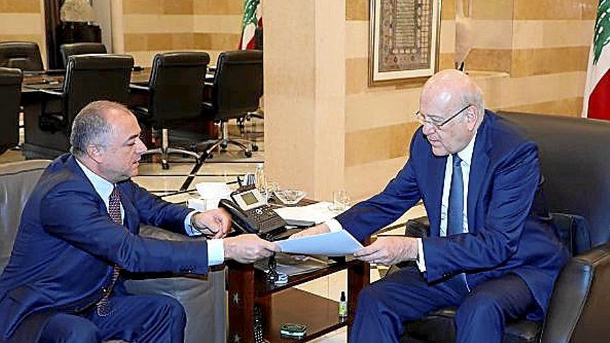 El primer ministro libanés, Najib Mikati, recibe el texto del acuerdo final de manos del negociador Elias Bou Saab.
Foto Efe