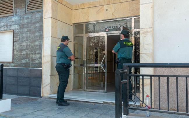 Dos agentes vigilan la entrada de la casa en la que una mujer de 50 años apareció muerta en Granada. Dos agentes vigilan la entrada de la casa en la que una mujer de 50 años apareció muerta en Granada.