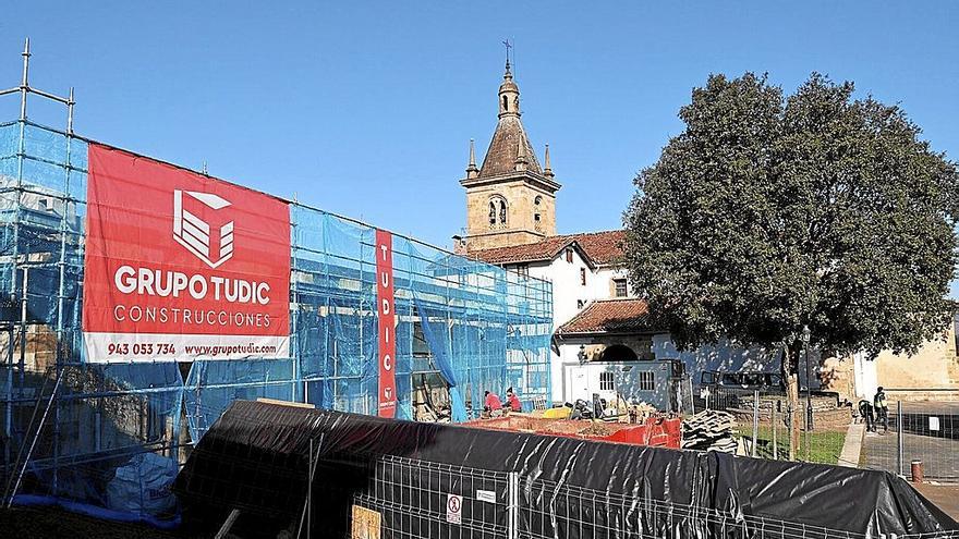 Las vallas de obra rodean Errementari Etxea en Zerain, con la lona de la empresa Tudic SL en primer término.