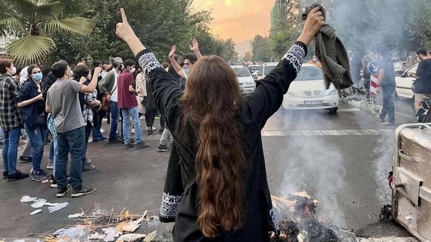 Una mujer iraní protesta en la calle por la muerte de Mahsa Amini.