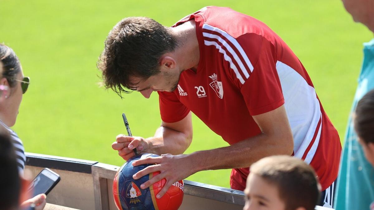 Aimar Oroz, firmando un balón de Osasuna a unos aficionados.