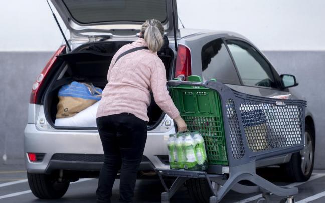 Una mujer mete la compra en el maletero de su vehículo al salir de un supermercado. Una mujer mete la compra en el maletero de su vehículo al salir de un supermercado.