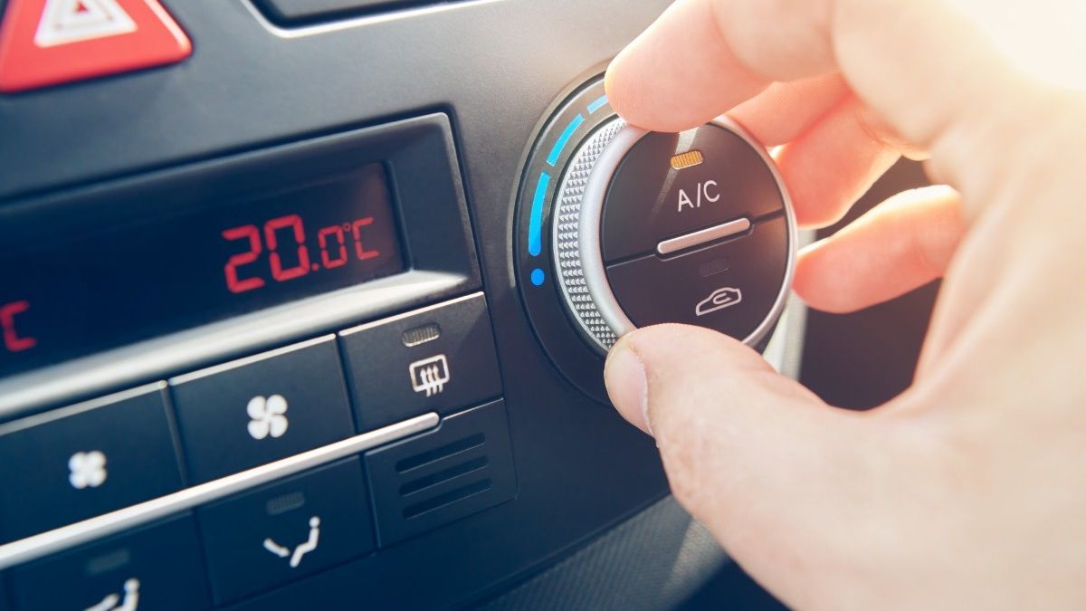 Un conductor regula el aire acondicionado de su coche.