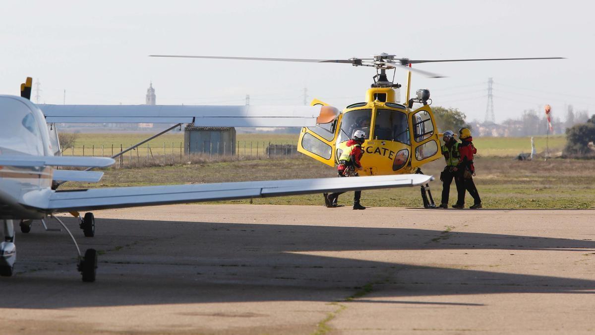 Efectivos del grupo de rescate se suben a un helicóptero de la Junta de Castilla y León para participar en la búsqueda de un ultraligero.