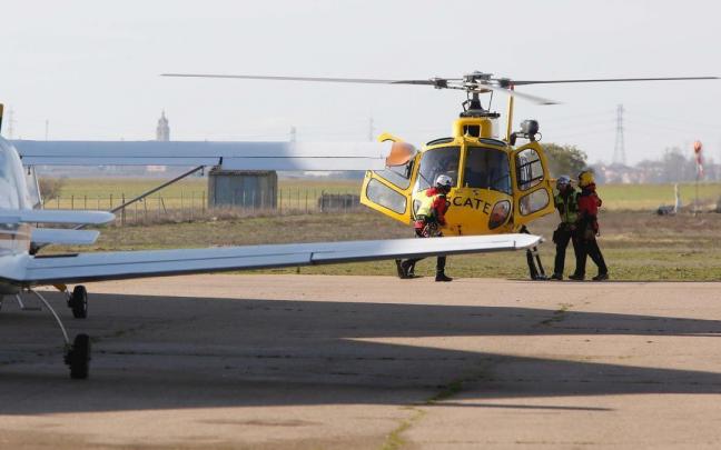 Efectivos del grupo de rescate se suben a un helicóptero de la Junta de Castilla y León para participar en la búsqueda de un ultraligero.