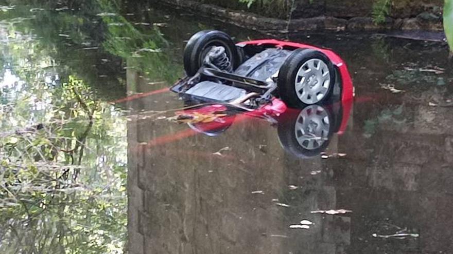 El coche accidentado, sumergido en el río.