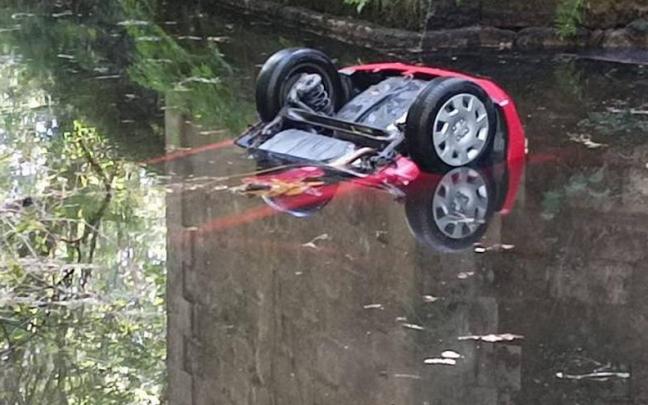 El coche accidentado, sumergido en el río. El coche accidentado, sumergido en el río.