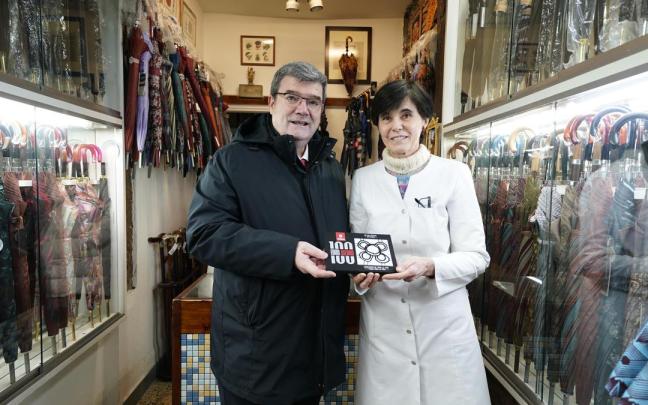 Juan Mari Aburto, alcalde de Bilbao, posa con Lourdes Leoz sosteniendo la baldosa que acredita que su paragüería es un 'comercio centenario' Juan Mari Aburto, alcalde de Bilbao, posa con Lourdes Leoz sosteniendo la baldosa que acredita que su paragüería es un 'comercio centenario'