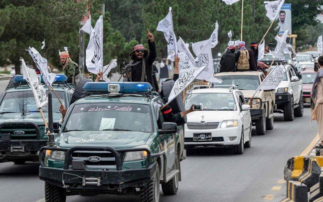 Talibanes celebrando su aniversario con las banderas que representan a los actuales mandatarios.