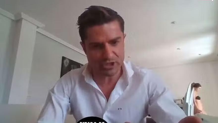 Alexia Rivas, pasando por detrás mientras Alfonso Merlos participaba en una videollamada desde su casa.