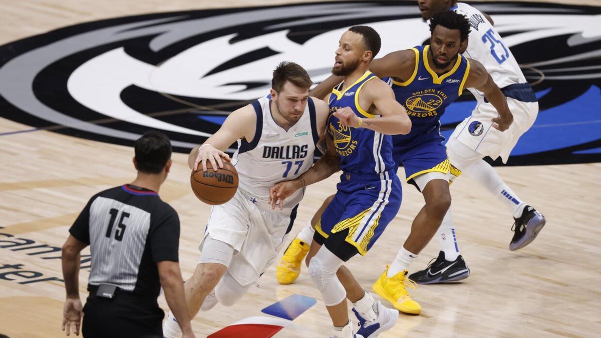 El jugador de los Dallas Mavericks Luka Doncic (2º izq.) en acción contra el base de los Golden State Warriors Stephen Curry (c).