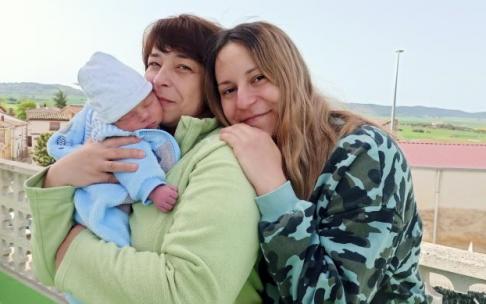 El pequeño Dan en brazos de su abuela y detrás su madre Anastasia en la casa de acogida de Abaigar