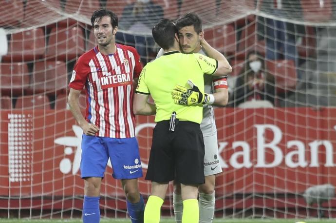 El árbitro Prieto Iglesias abraza a Diego Mariño tras la derrota del Sporting en la última jornada de Segunda.