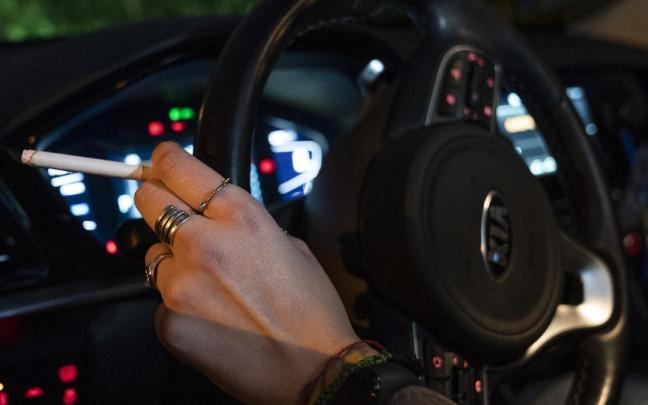 Una persona fuma en el coche. Una persona fuma en el coche.