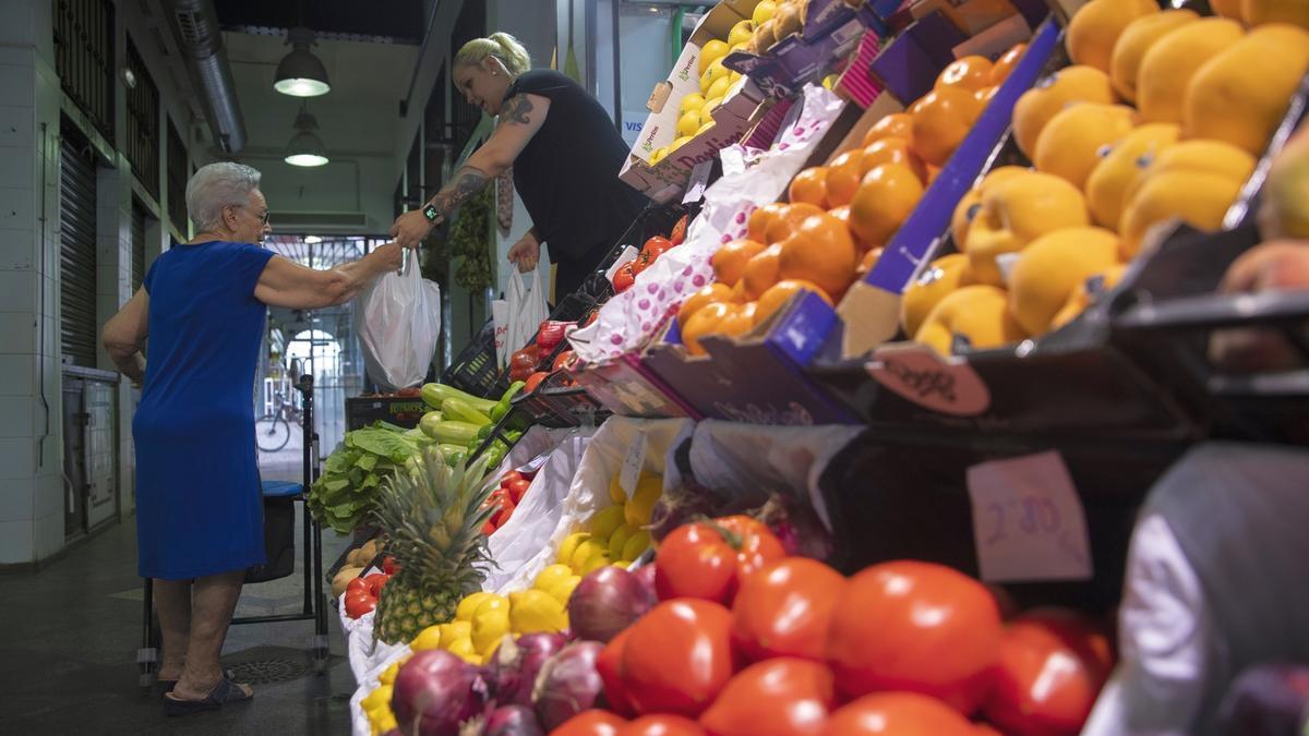 Un puesto de frutas y verduras de un mercado de abastos.