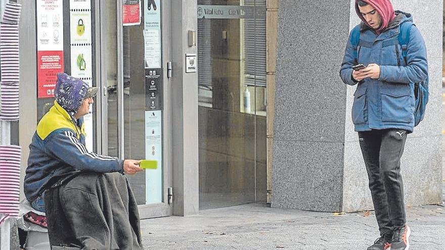 Una persona pidiendo limosna en una calle de Vitoria.