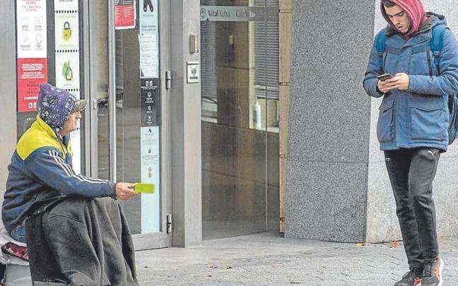 Una persona pidiendo limosna en una calle de Vitoria.