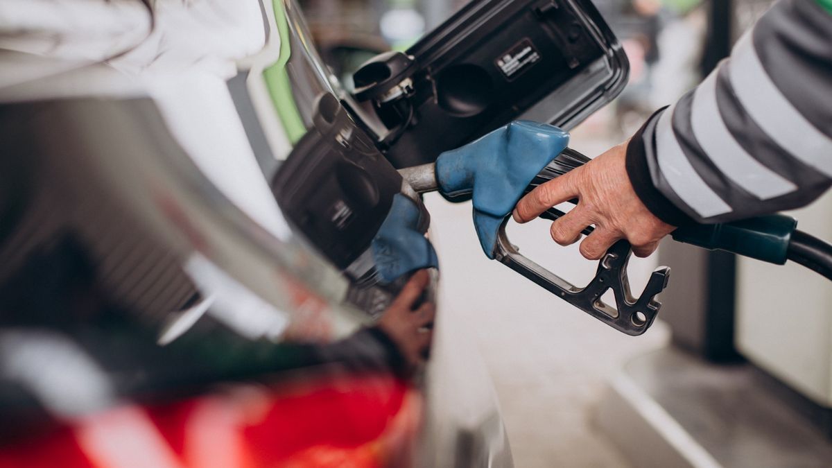 Un empleado de una gasolinera echa gasolina en el vehículo de un cliente.