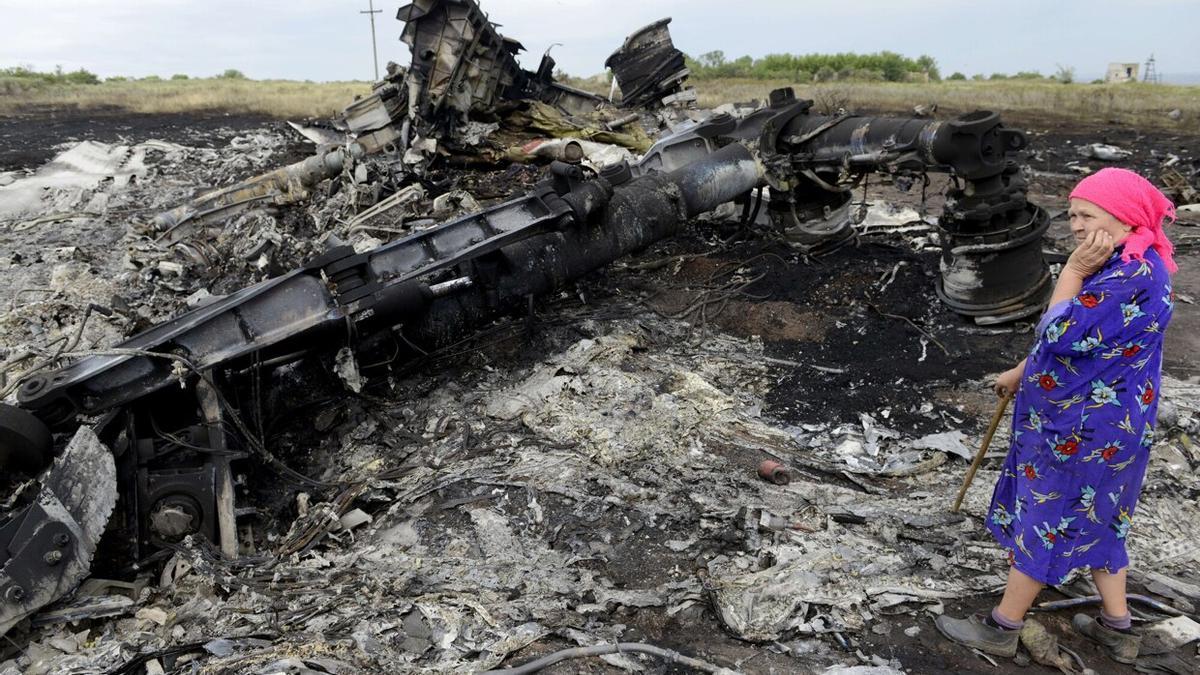 Una mujer junto a los restos del avión MH17 derribado.