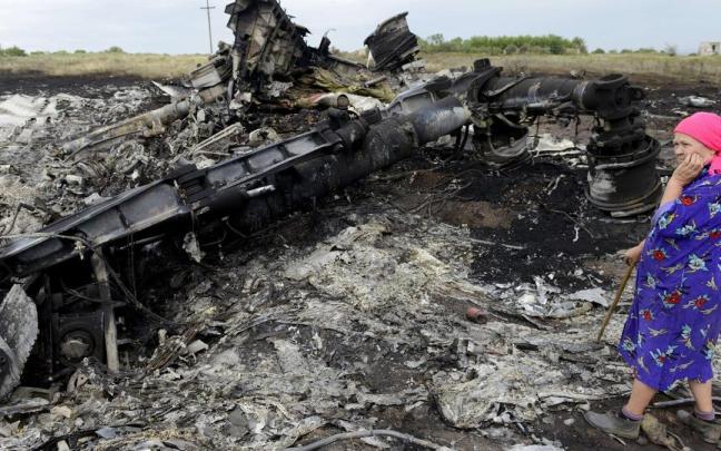 Una mujer junto a los restos del avión MH17 derribado. Una mujer junto a los restos del avión MH17 derribado.