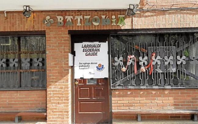 Pancarta contra la Ertzaintza y bozales colgados en la puerta del batzoki de Zaldibar. Pancarta contra la Ertzaintza y bozales colgados en la puerta del batzoki de Zaldibar.