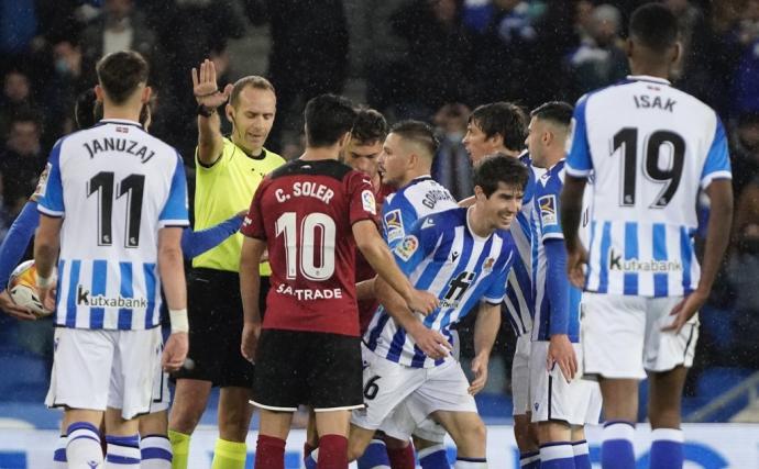 Los jugadores de la Real, con Aritz sonriendo irónicamente, protestan la roja al beasaindarra.