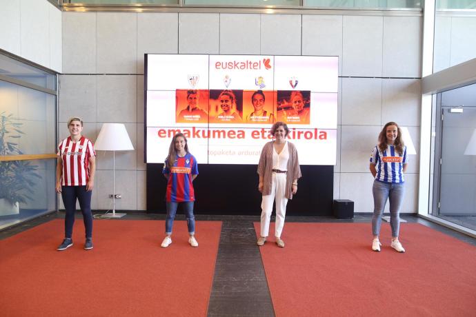 Garazi Murua, del Athletic; Sheila Elorza, del Eibar; y Ane Etxezarreta, de la Real Sociedad, posan con la representante de Euskaltel.