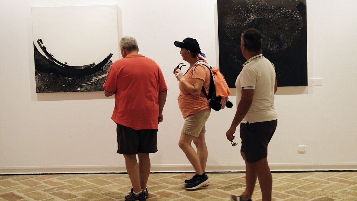 Asistentes probando el código QR para visualizar la parte animada de la obra.