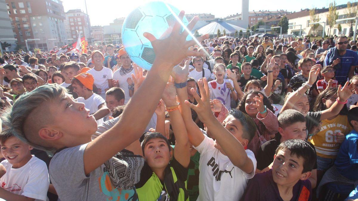 Niños cogiendo los regalos repartidos tras el lanzamiento del cohete de fiestas.