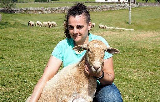 Ana Mari Bengotxea Lastiri junto a una oveja de las que ofrecen en adopción, en un prado del caserío Etxelekua.