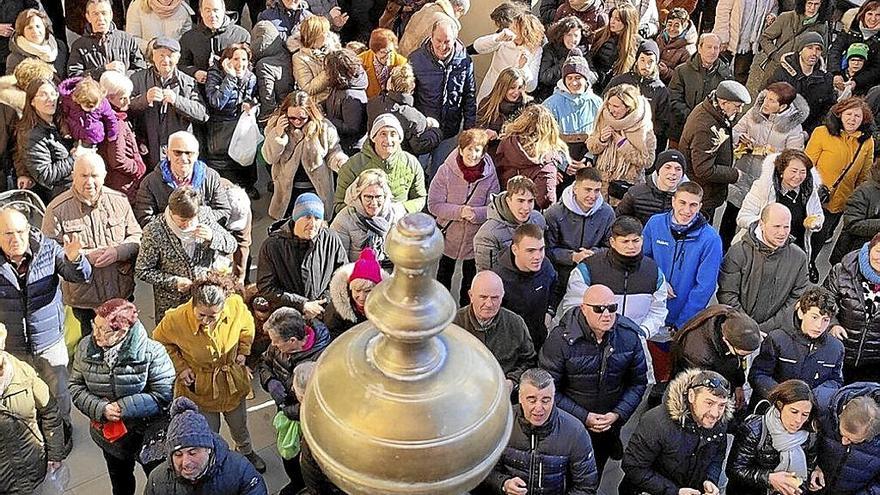 Los arqueños y arqueñas reciben el pan lanzado ‘a rebuche’ desde el consistorio.