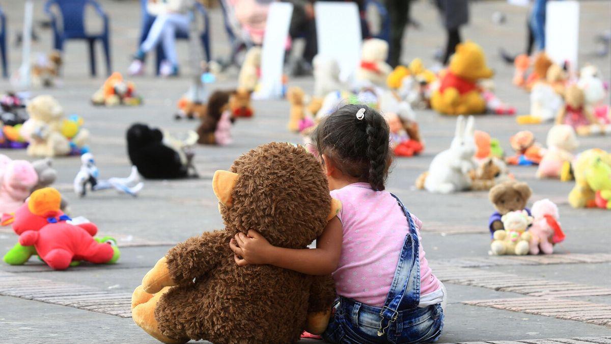 Una niña abraza un muñeco durante una protesta contra del abuso sexual infantil.