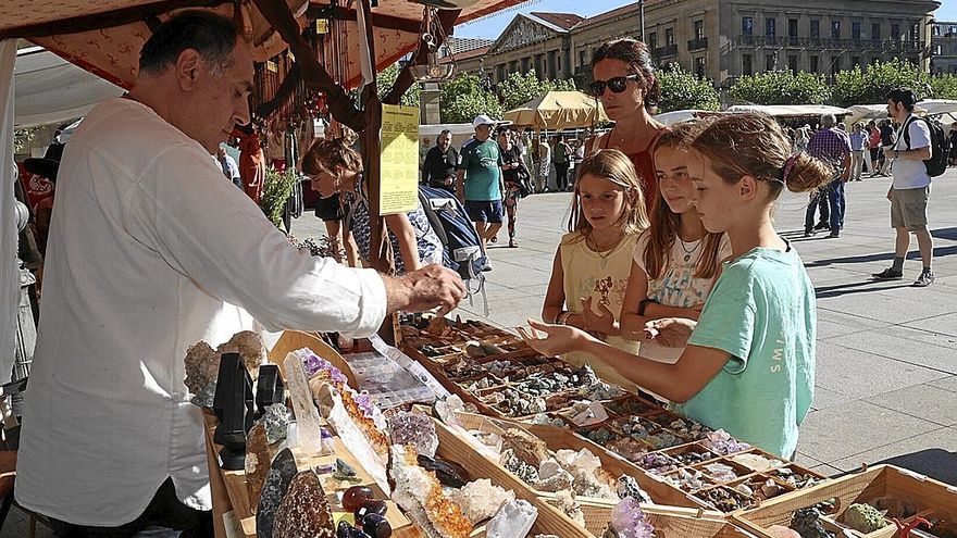Juan Félix atiende a clientes en su puesto de venta de minerales durante el Mercado Medieval en la Plaza del Castillo de Pamplona.