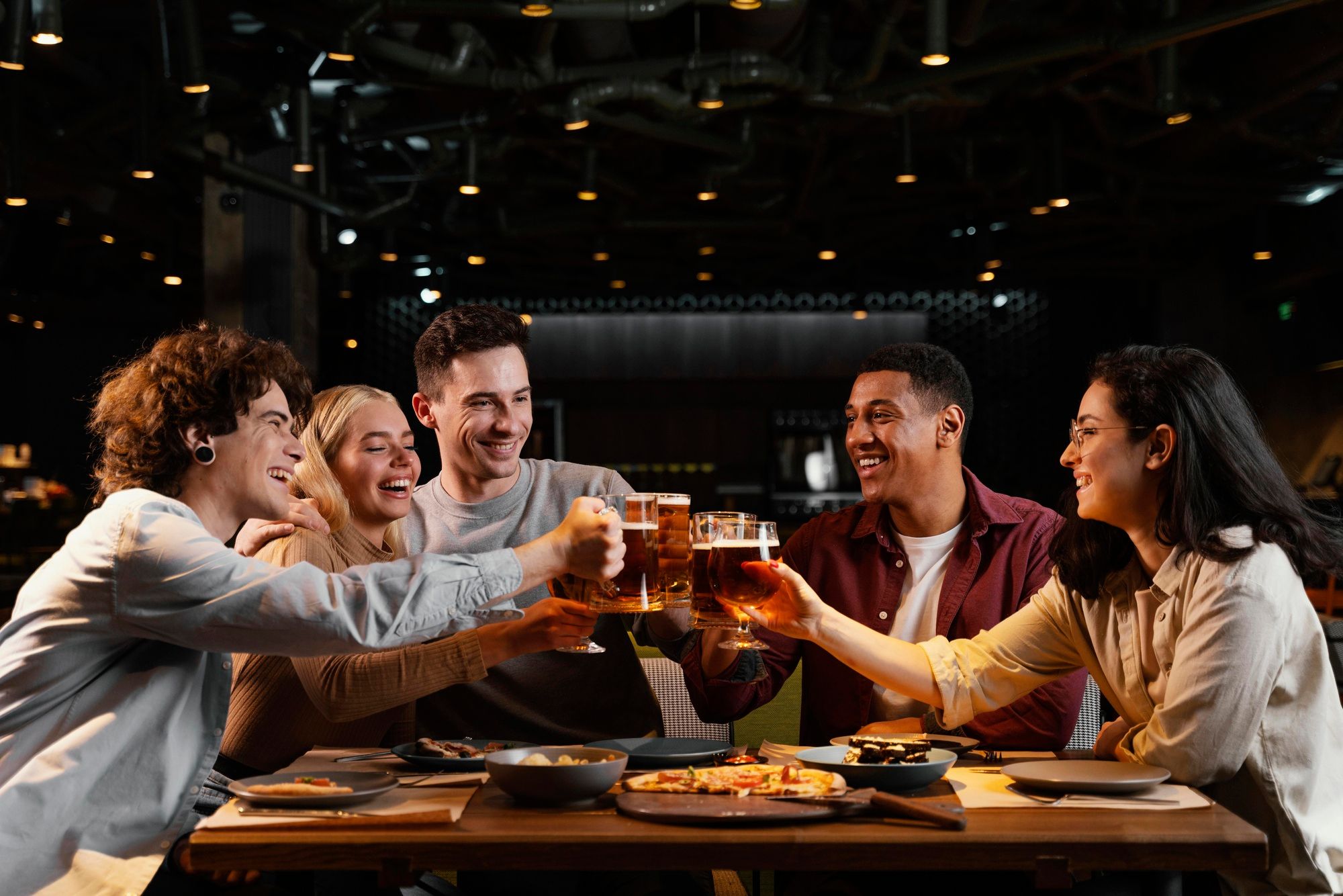 Un grupo de chicos y chicas brinda con cerveza.