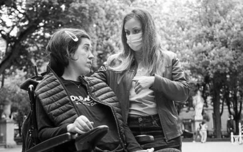 Lerro hauekin batera doan irudian, Sara Calvo Gasteizko Alboko Esklerosi Amiotrofikoaren Elkarteko presidentea, bertako gaixo batekin. Biak Gasteizko hiritik batera paseatzen duten bitartean. Elkartetik ikerketarekin jarraitzea eskatzen dute. Argazkia: Jo