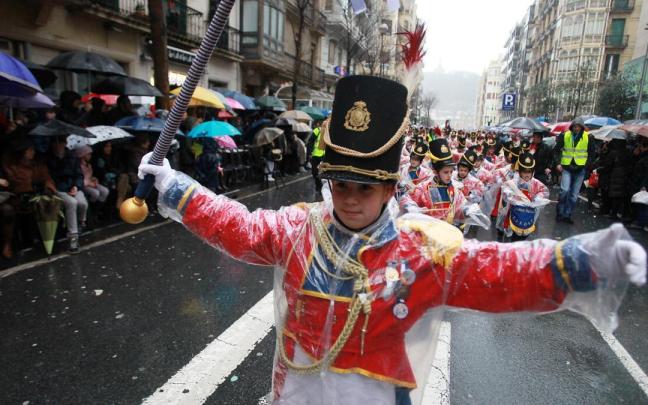 Integrantes de Maria Reina en la tamborrada infantil, protegidos por chubasqueros