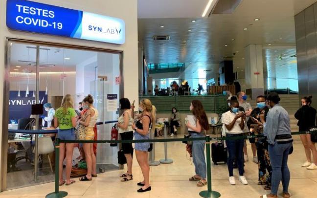 Varias personas, protegidas con sus mascarillas, en un aeropuerto. Varias personas, protegidas con sus mascarillas, en un aeropuerto.
