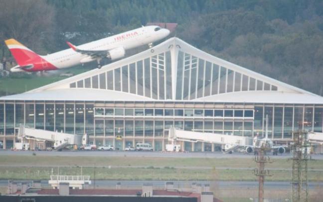 Un avión de Iberia despega con la terminal de Loiu al fondo