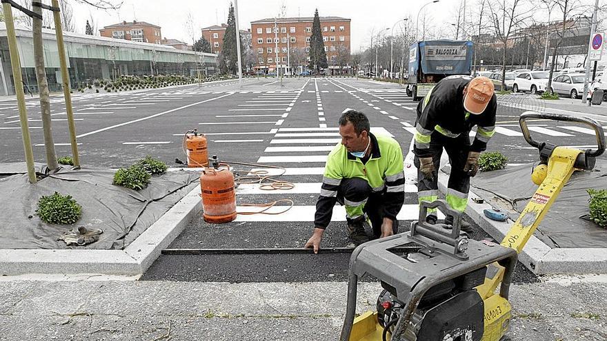 Dos obreros trabajan en el arreglo de una carretera. | FOTO: PILAR BARCO