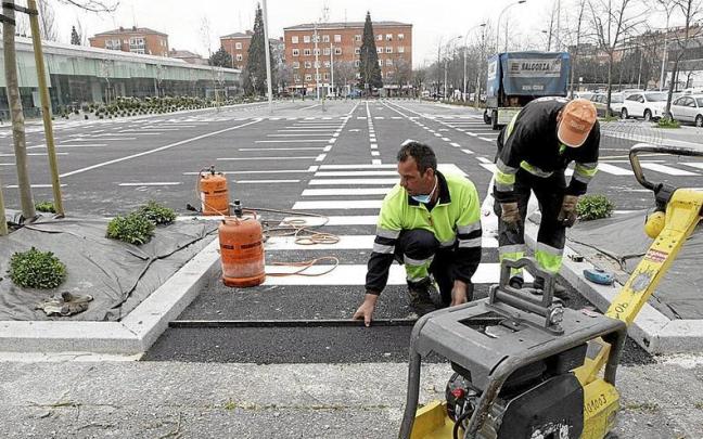 Dos obreros trabajan en el arreglo de una carretera. | FOTO: PILAR BARCO Dos obreros trabajan en el arreglo de una carretera. | FOTO: PILAR BARCO