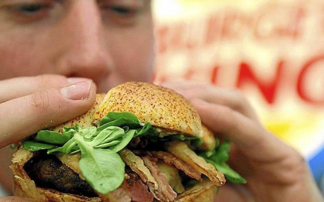 Un adolescente a punto de comerse una hamburguesa. | FOTO: E.PRESS