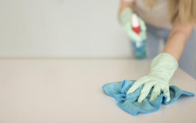 Una mujer limpiando una mesa.
