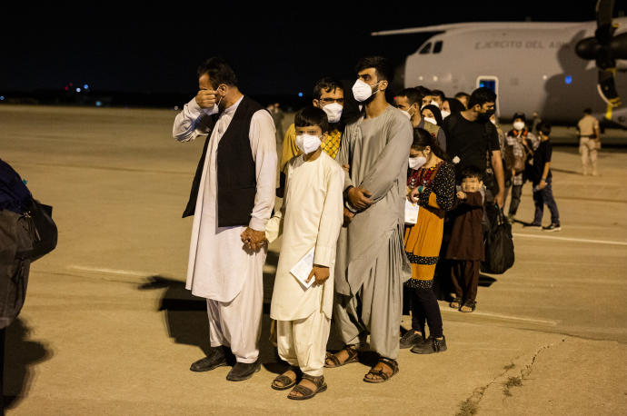 Varios de los ciudadanos afganos evacuados de Kabul, tras llegar a la base de Torrejón de Ardoz.