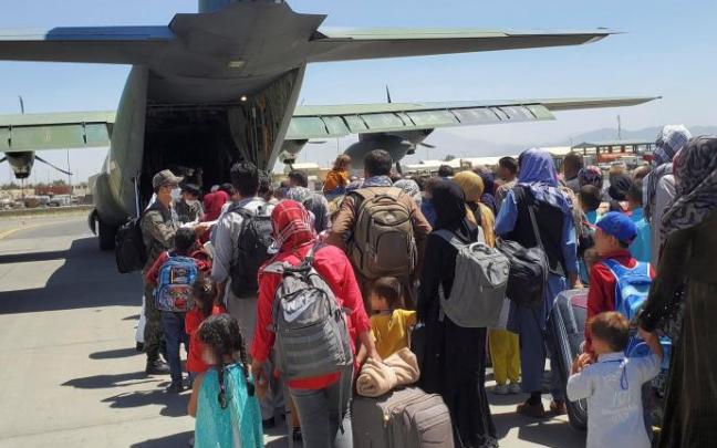 Decenas de afganos esperan a subir a un avión para ser evacuados. Decenas de afganos esperan a subir a un avión para ser evacuados.